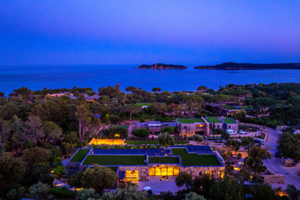 L'hôtel illuminé dans le maquis, la mer et les îles au loin