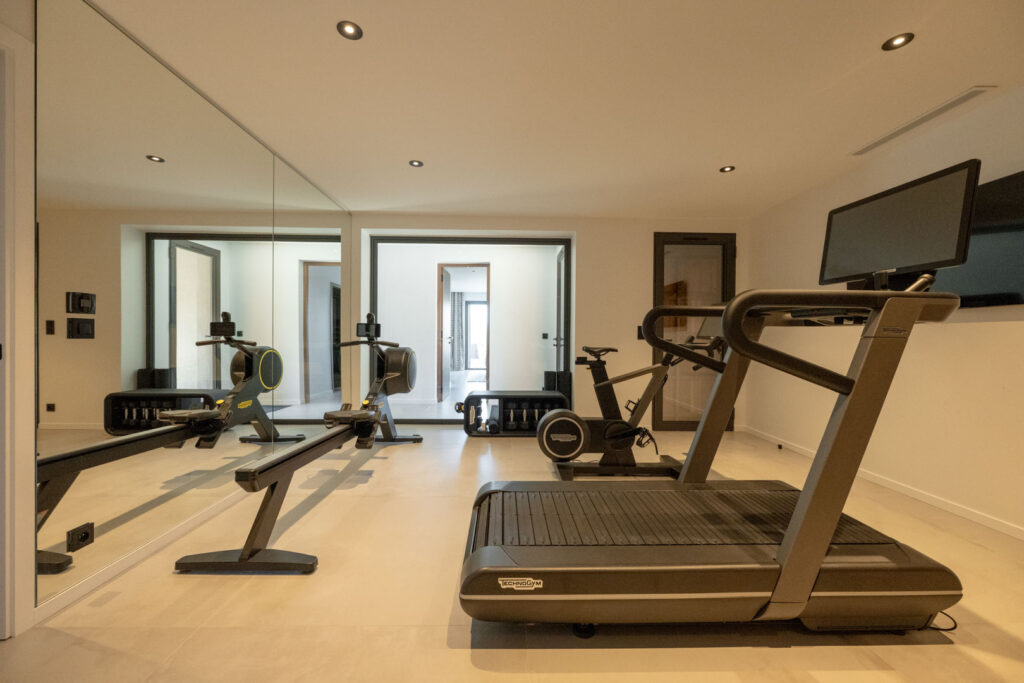 Salle de sport avec tapis de course et rameur